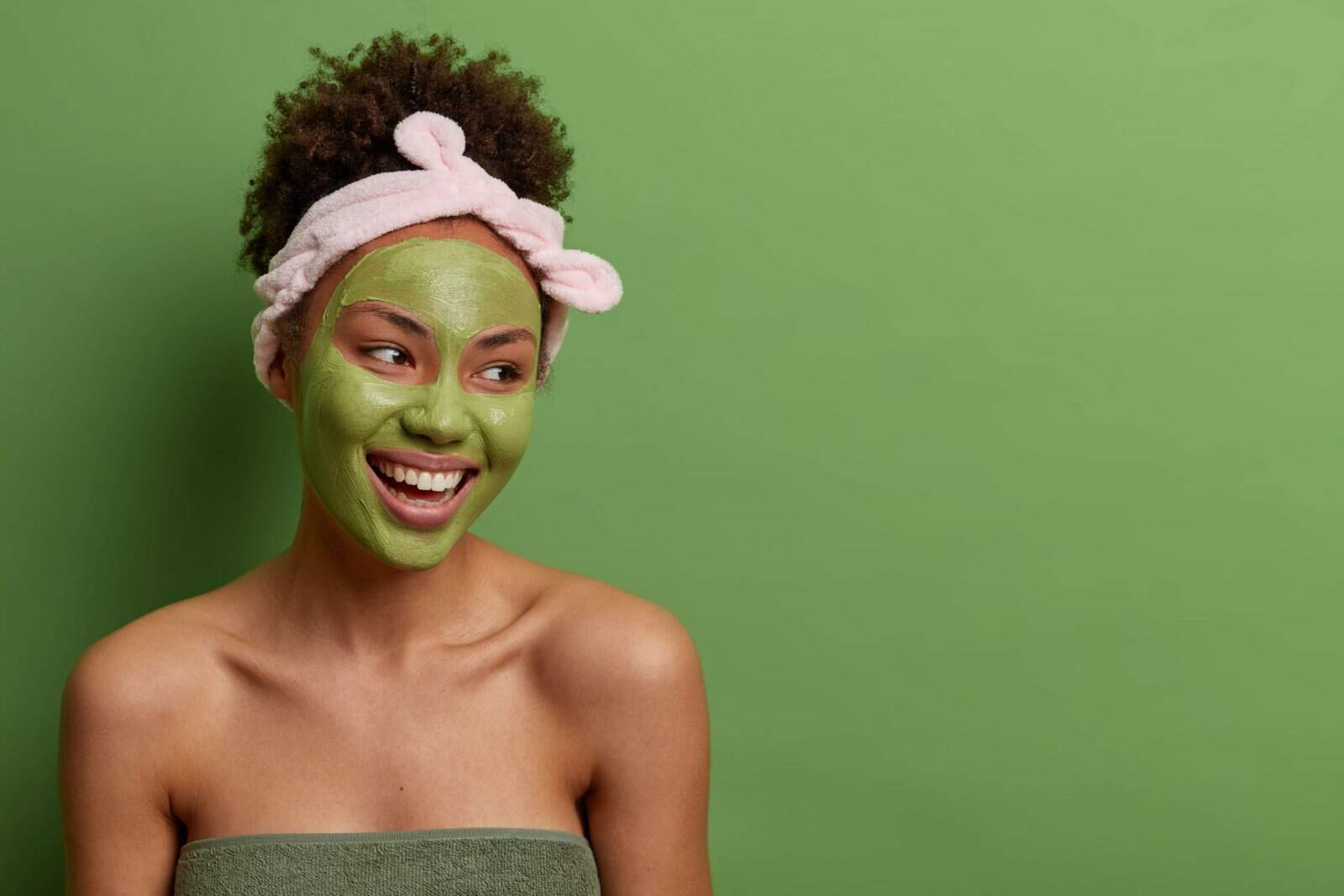 mulher com fundo verde cuidando da pele