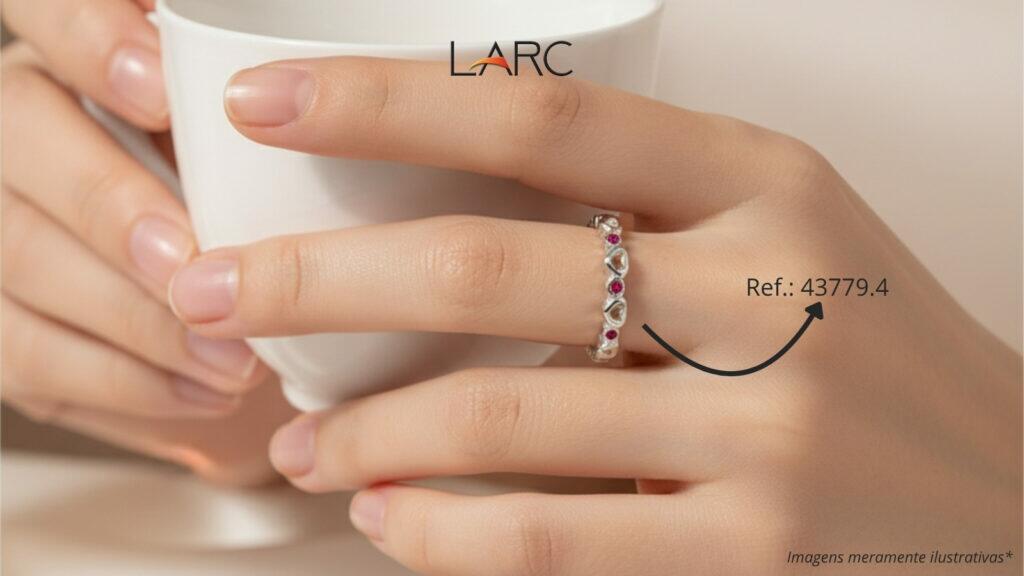 Mão de mulher segurando uma xícara, destacando um anel com pedras de zircônia