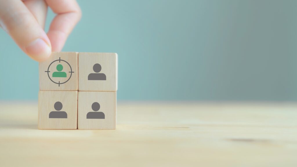 Blocos de madeira com ícones de pessoas representando a definição de público-alvo.